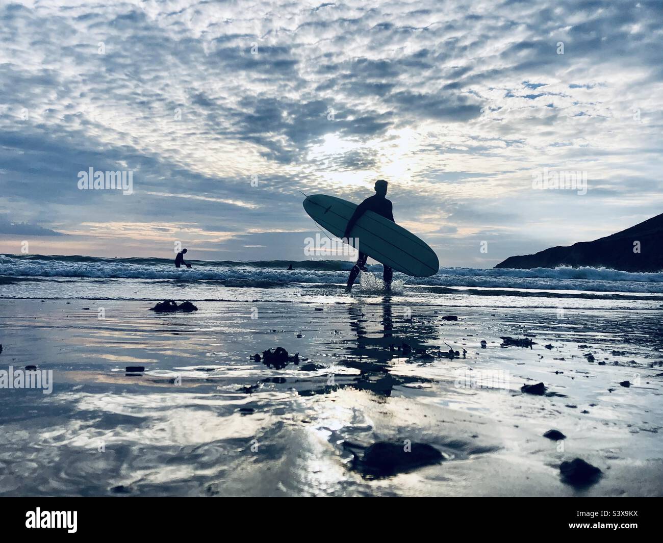 Un surfeur part de l'eau avec sa planche à repasser - Image de stock capturée avec un smartphone