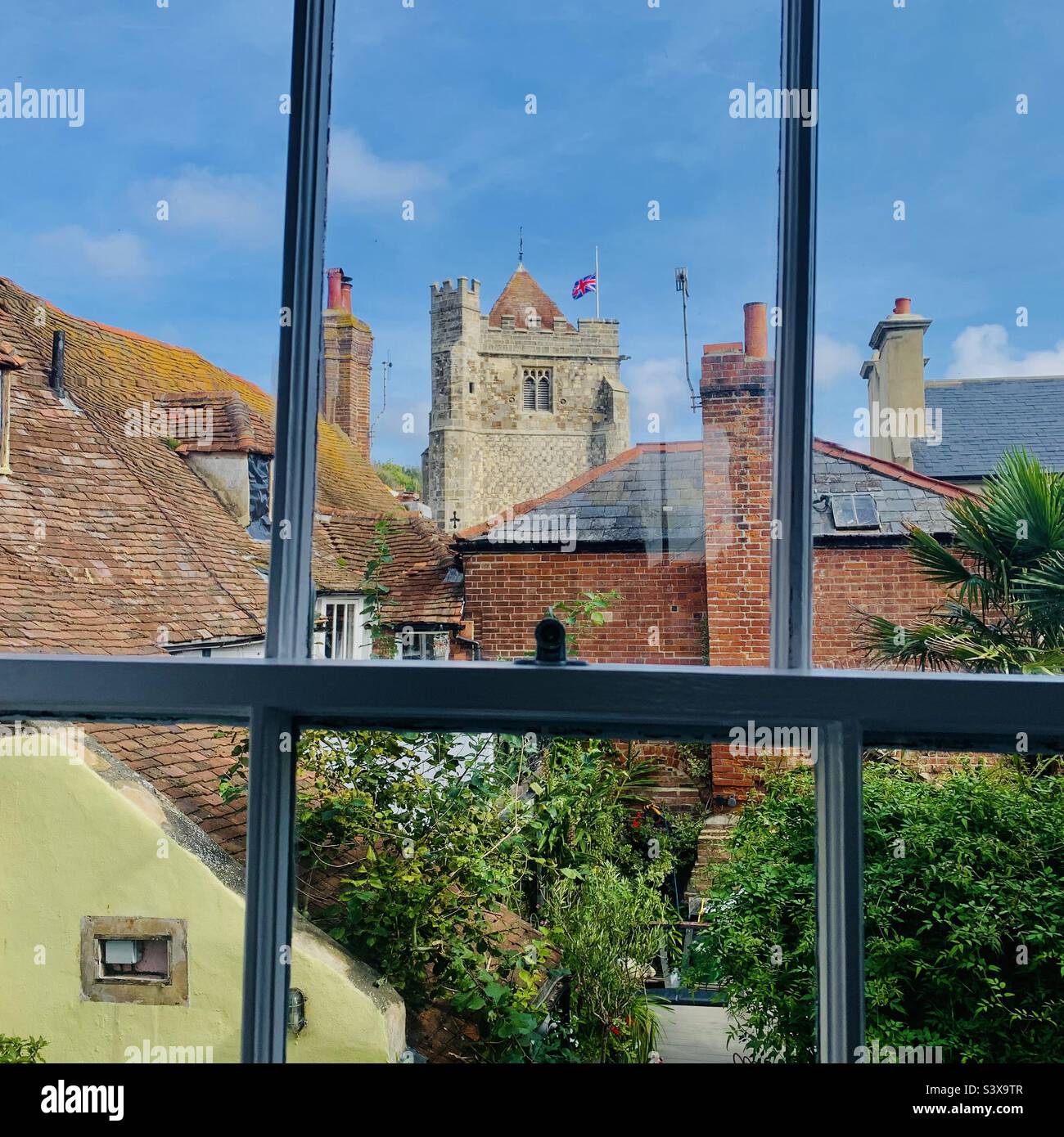 Les toits de la vieille ville de Hastings et l'église avec drapeau de l'Union respectueusement à la moitié du mât en deuil de la reine Elizabeth II - Image de stock capturée avec un smartphone