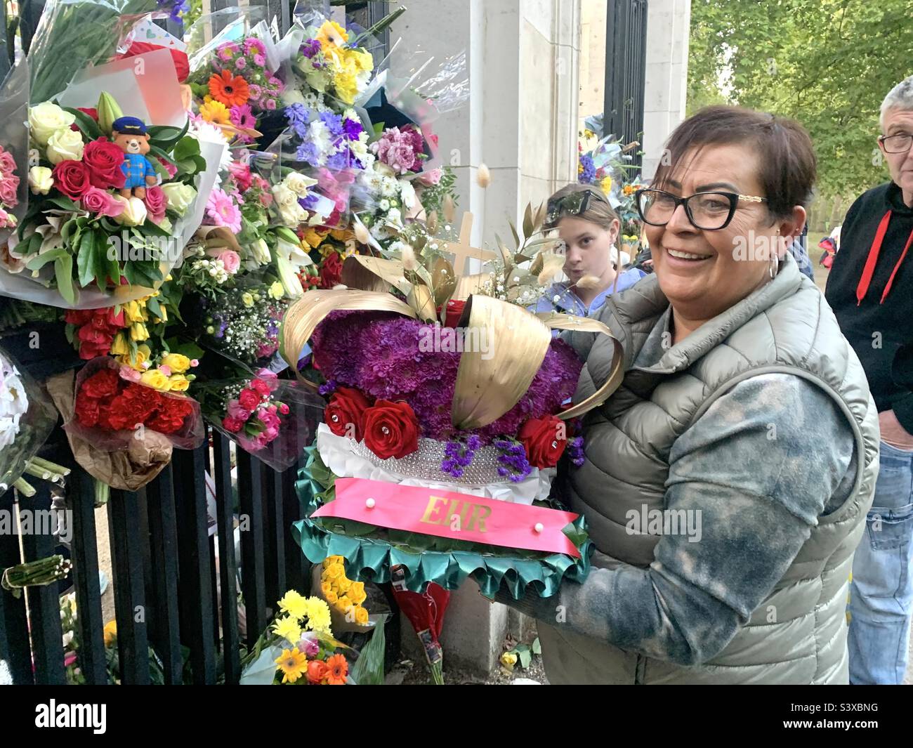 Femme avec des fleurs en hommage à la reine au St James Park de londres Banque D'Images