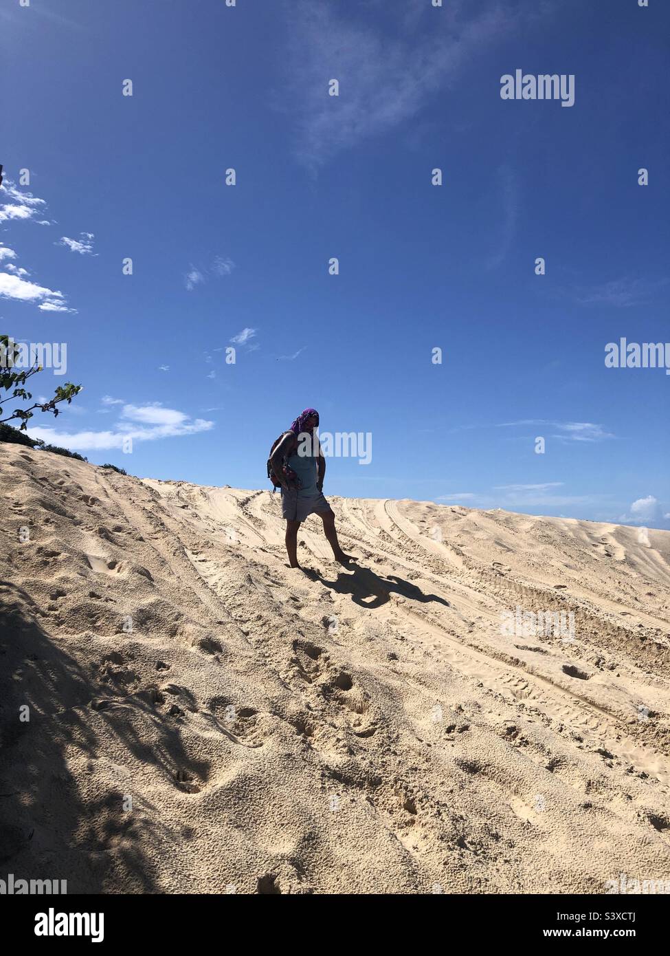 Un homme debout sur la colline d'une dune de sable. - Image de stock capturée avec un smartphone