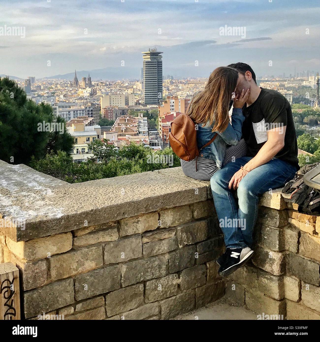 Deux amoureux baiser sur un mur sur la montagne de Montjuïc donnant sur la ville de Barcelone - Image de stock capturée avec un smartphone