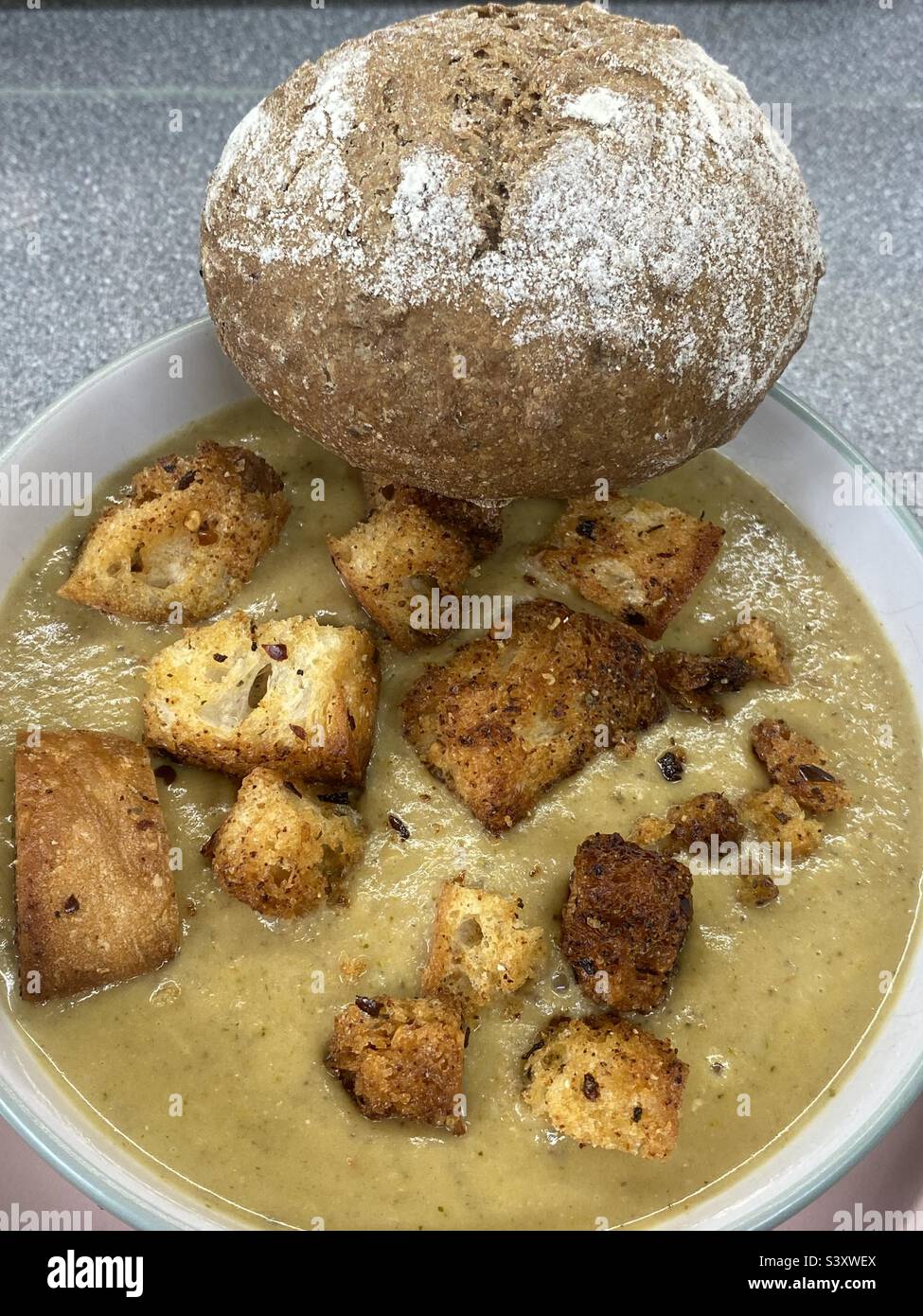 Soupe maison au chou-fleur, brocoli et fromage bleu avec croûtons Air Fryer et un rouleau d'épeautre et de tournesol - Image de stock capturée avec un smartphone