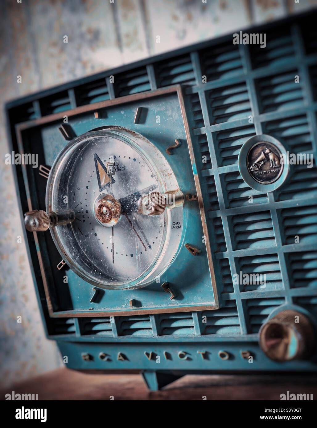 Radio-réveil vintage RCA couleur sarcelle sur une étagère en bois contre papier peint floral vintage Banque D'Images