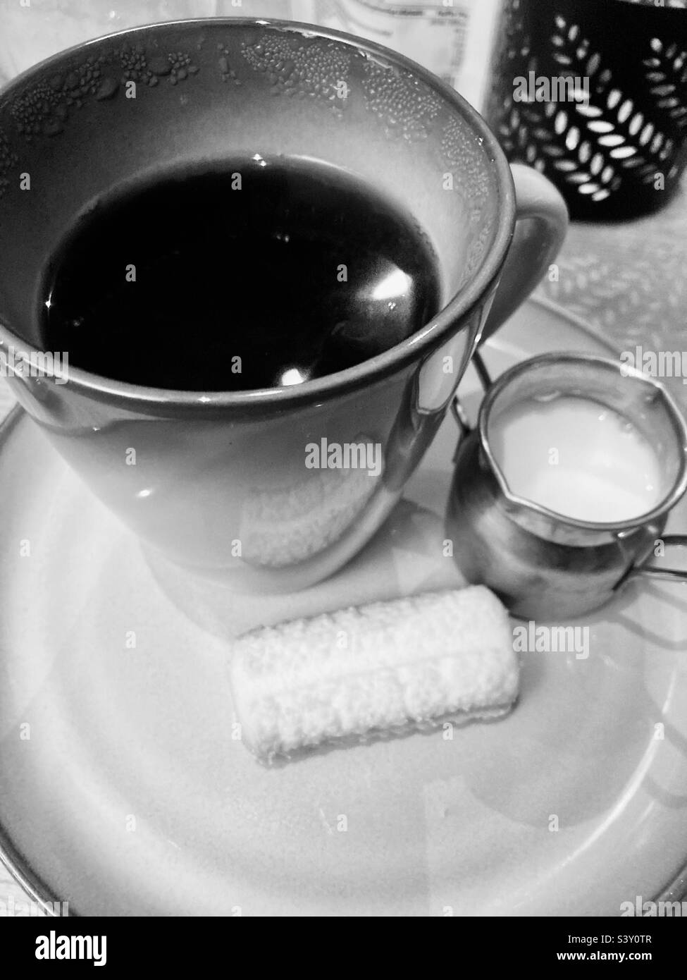 Café de l'après-midi avec du lait et un biscuit en noir et blanc Banque D'Images