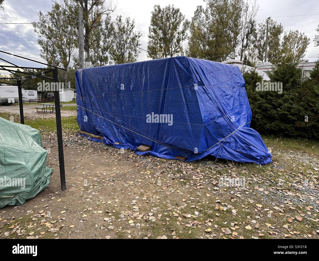 Campeur recouvert d'une bâche bleue. Banque D'Images