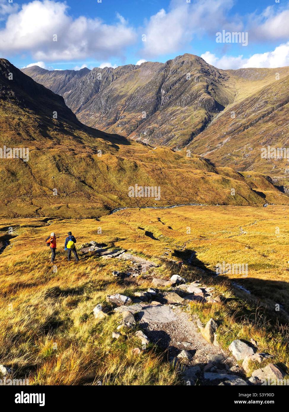 Marcheurs sur le chemin et les pentes de Munro Buachaville Etive Beag, avec vue sur la crête d'Aonach Eagach, Glencoe, Écosse Banque D'Images