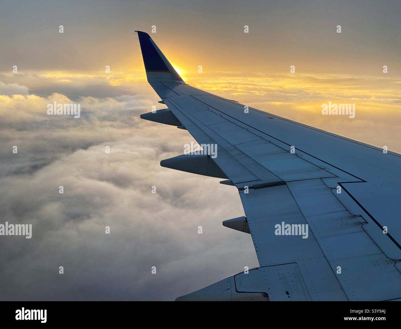 Voler à travers les nuages au coucher du soleil. Banque D'Images