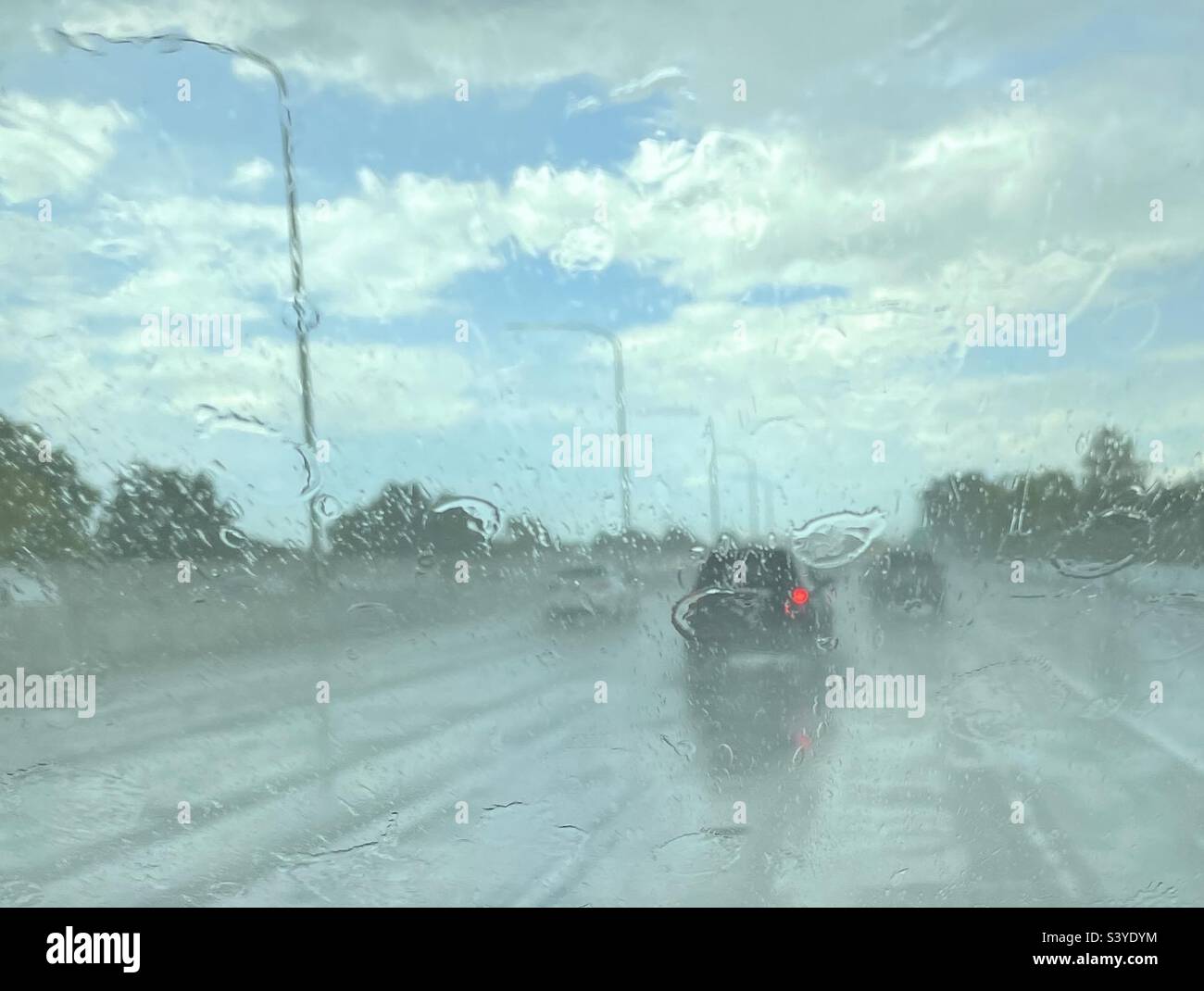 Conduite dans une descente monsoonale sur une autoroute de l'Utah, aux États-Unis vers la fin de l'été. Le pare-brise et la route accumulent rapidement l'eau, ce qui rend difficile la vue et la navigation. Tout est humide. Banque D'Images