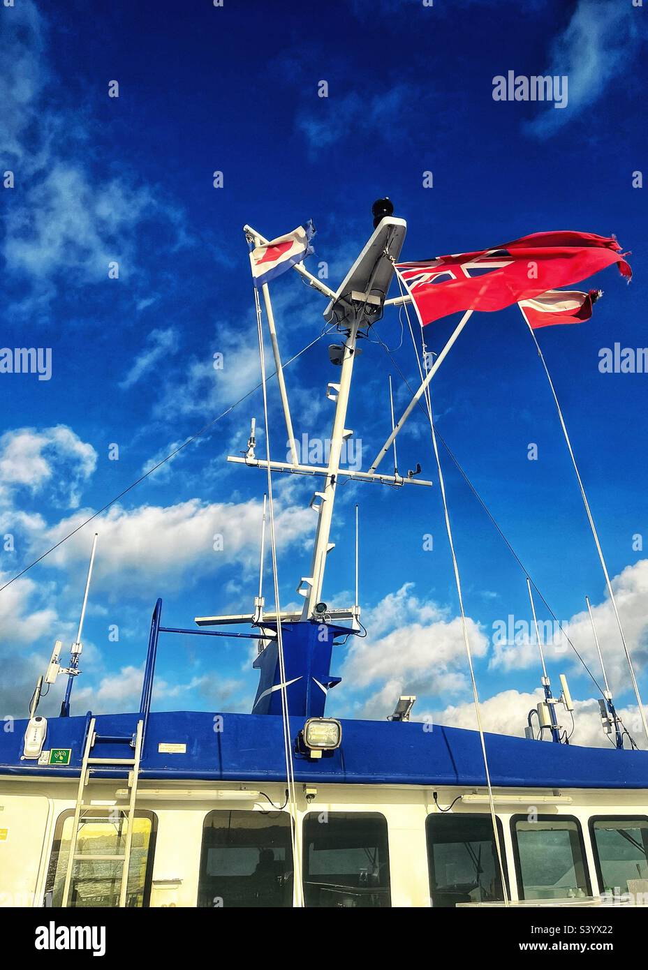 Les drapeaux volent sur le catamaran, y compris le Red Ensign - le drapeau du marchand et de l'expédition privée au Royaume-Uni Banque D'Images