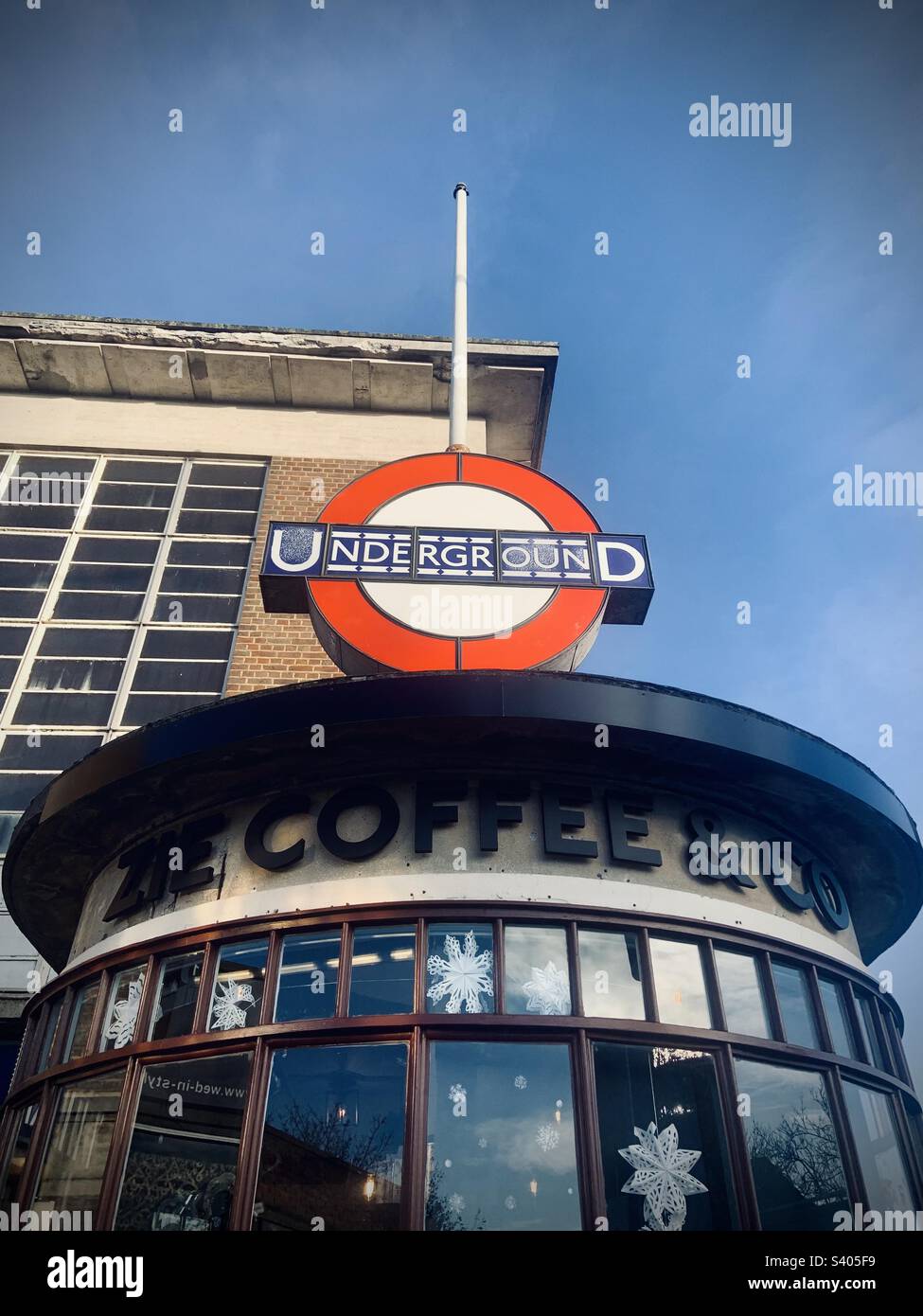 Un café-restaurant sous le panneau rond-point Art déco du métro de Londres. Rayners Lane. Banque D'Images