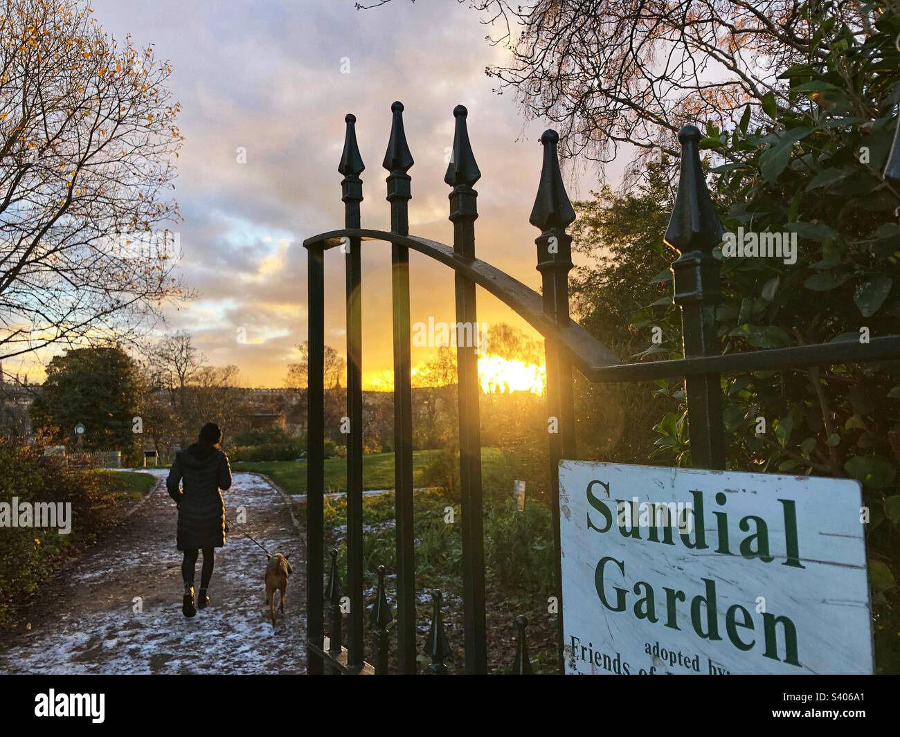 Marche du chien dans la neige et coucher de soleil d'hiver au jardin Sundial dans le parc - Image de stock capturée avec un smartphone