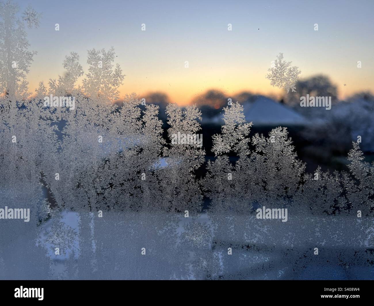 Givre sur une fenêtre au lever du soleil Banque D'Images