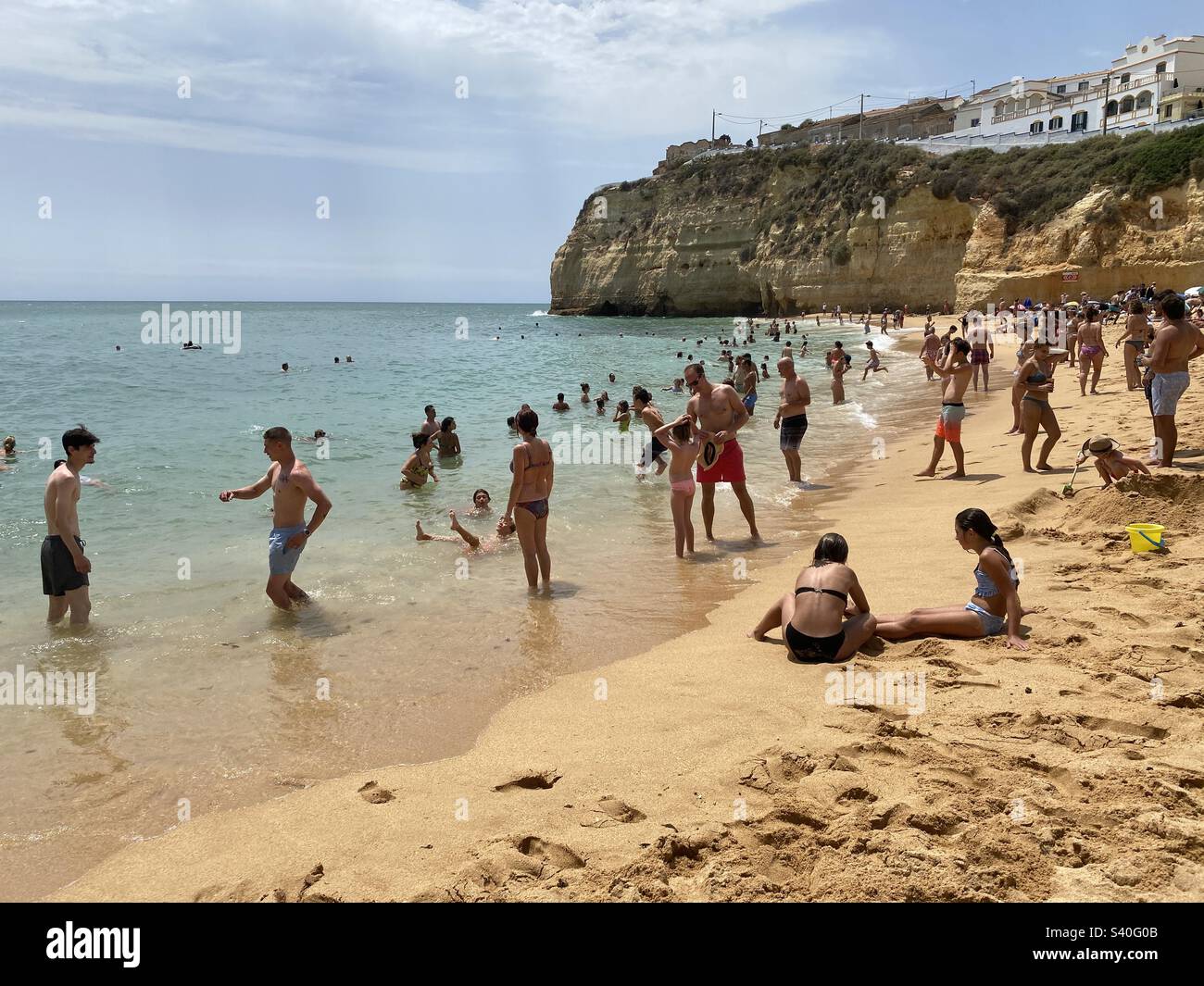 Touristes sur la plage et dans la mer à Carvoeiro sur l'Algarve, Portugal Banque D'Images