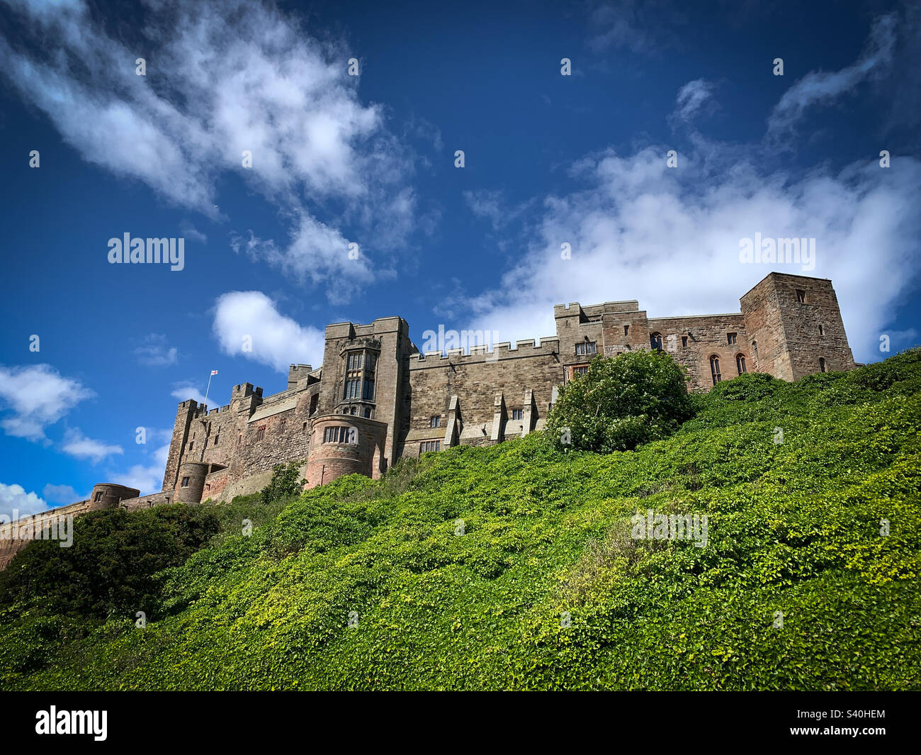 Vue sur l'imposant château de Bamburgh lors d'une journée ensoleillée d'été, Northumberland, Royaume-Uni Banque D'Images