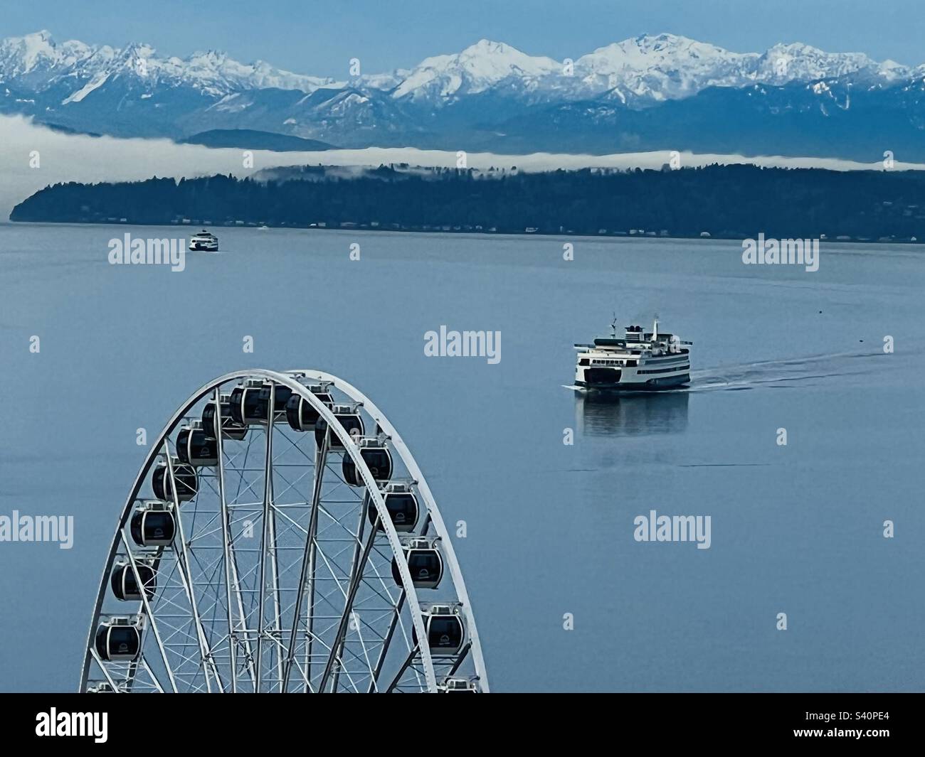 Ferries traversant la mer de Salish jusqu'à Elliot Bay à Seattle, aux États-Unis, avec les montagnes olympiques remplies de neige qui s'affichent au lever du soleil. - Image de stock capturée avec un smartphone