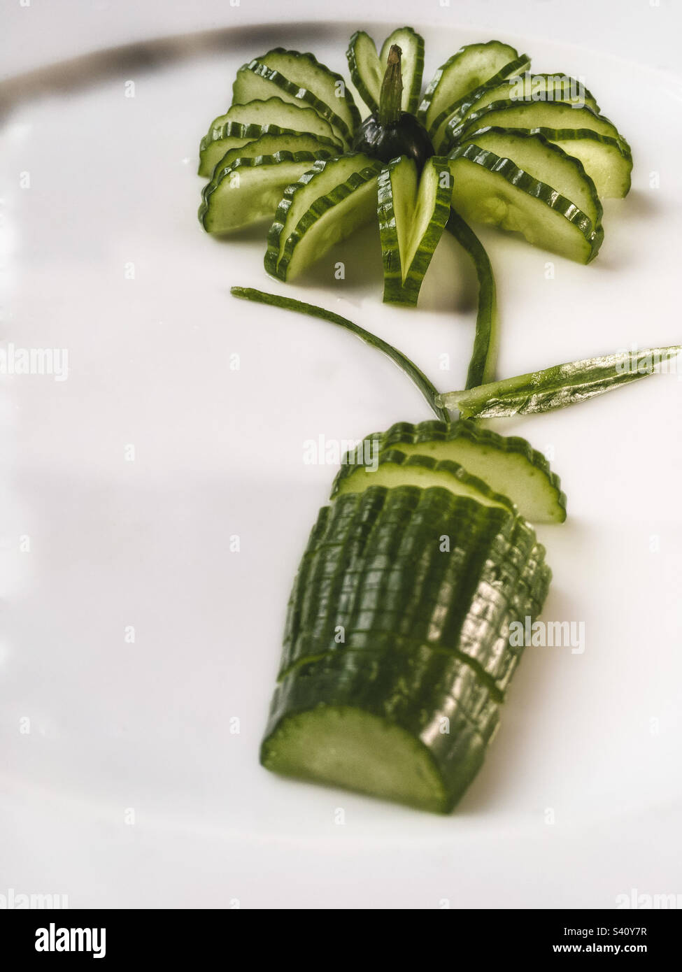 Fleur de concombre sur un pot sur une assiette blanche Banque D'Images