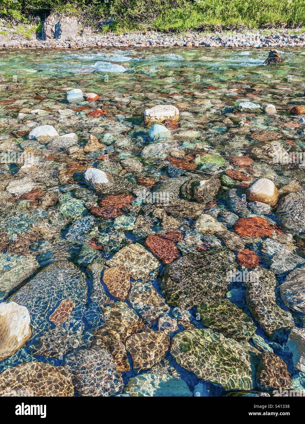 Rochers colorés dans un ruisseau avec de l'eau claire qui coule au-dessus d'eux Banque D'Images