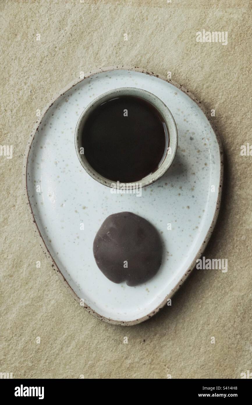 Une tasse de café et un biscuit au chocolat sur un plateau en pierre Banque D'Images