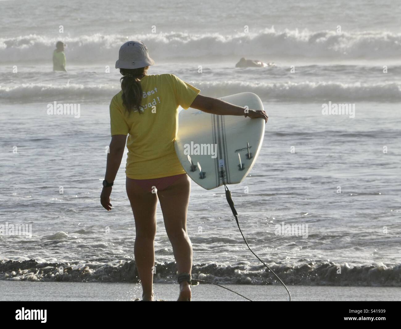 Une surfeuse se dirige vers la mer avec sa planche à ses côtés au Costa Rica Banque D'Images