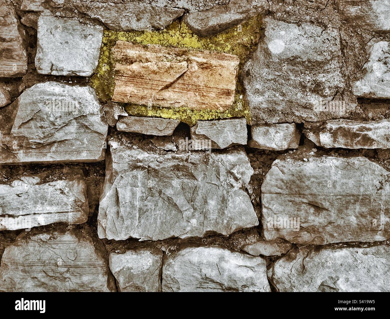 Un mur de pierre grossier taillé avec un effet grunge ajouté. Banque D'Images