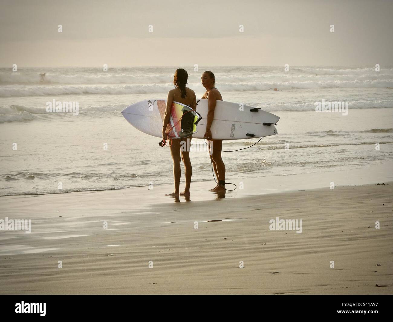 Deux surfeurs féminins discutent des conditions avant d'aller dans la mer au Costa Rica Banque D'Images