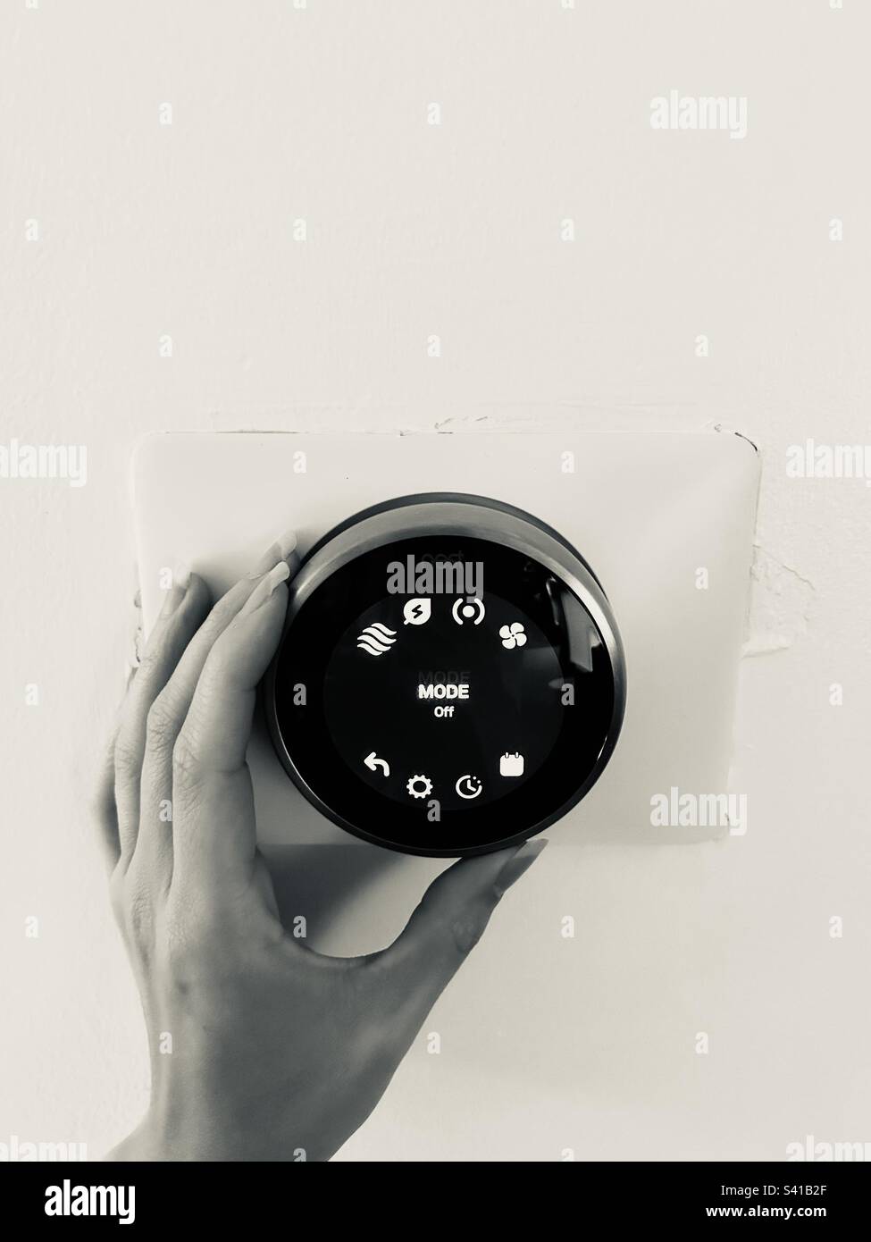 Imbriquez les réglages du mode de thermostat intelligent en noir et blanc à la main Banque D'Images