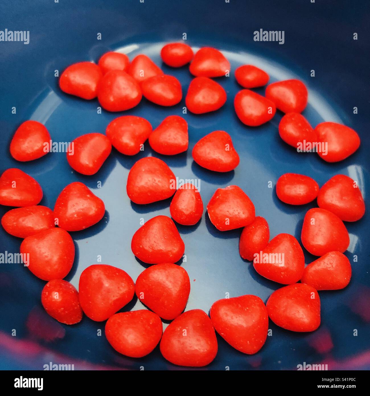 Bonbons cœur rouge pour la journée des Valentinés - sur fond bleu Banque D'Images
