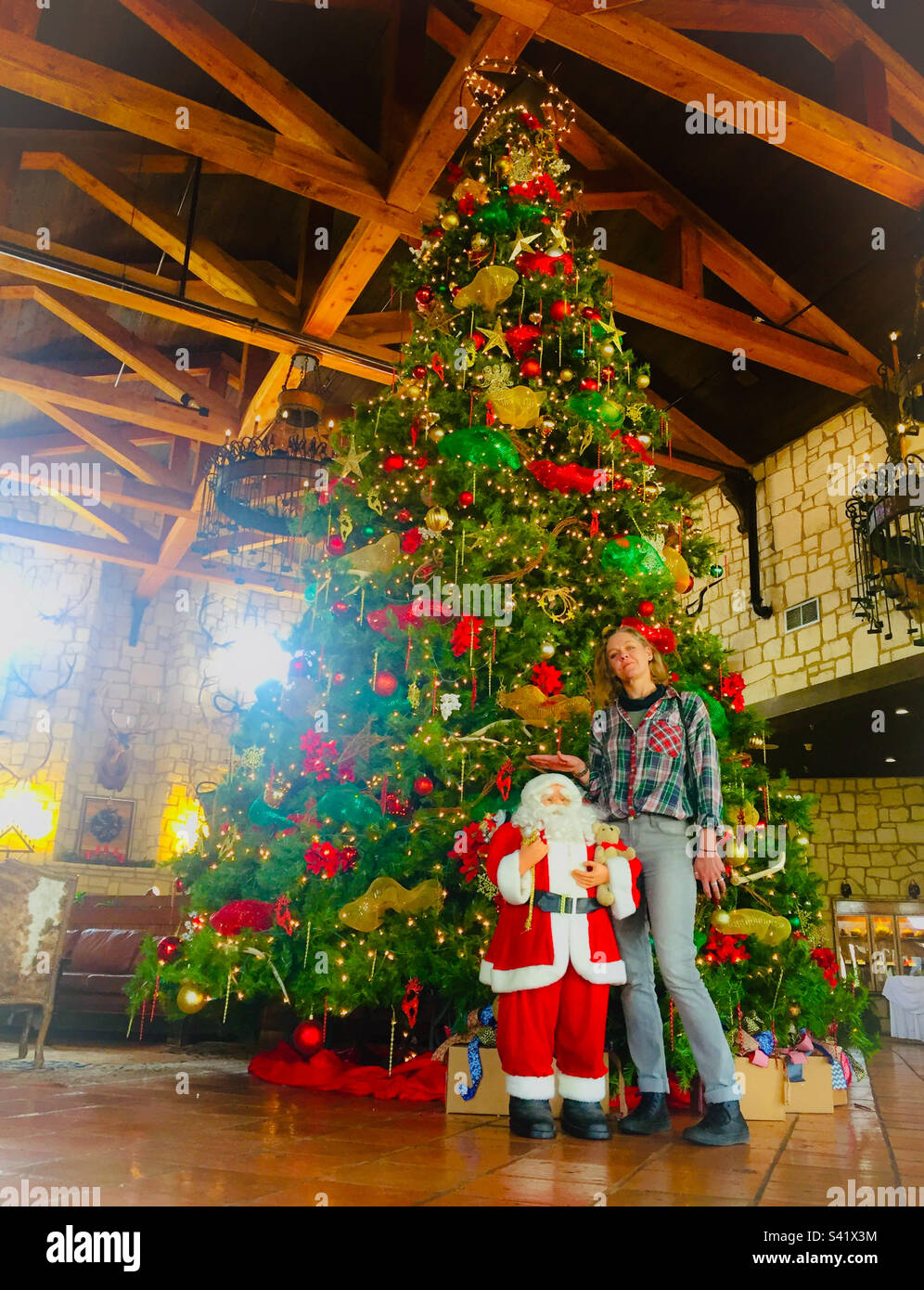 Une femme posant par un arbre de Noël et un petit Santa au Texas USA - Image de stock capturée avec un smartphone
