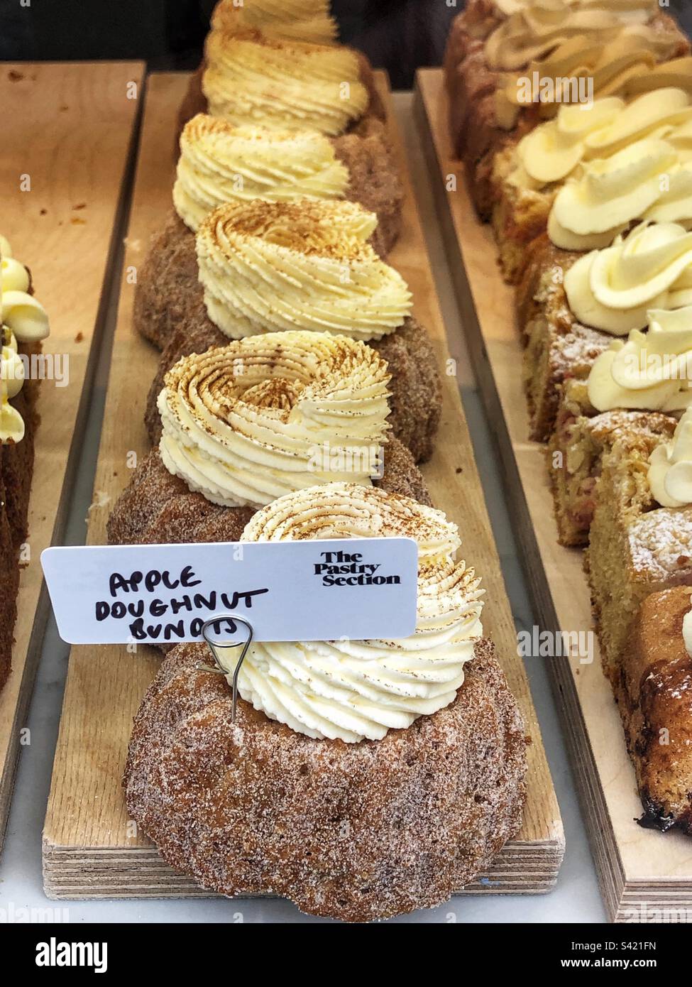 Forfaits de beignets aux pommes dans la fenêtre de la boulangerie Banque D'Images