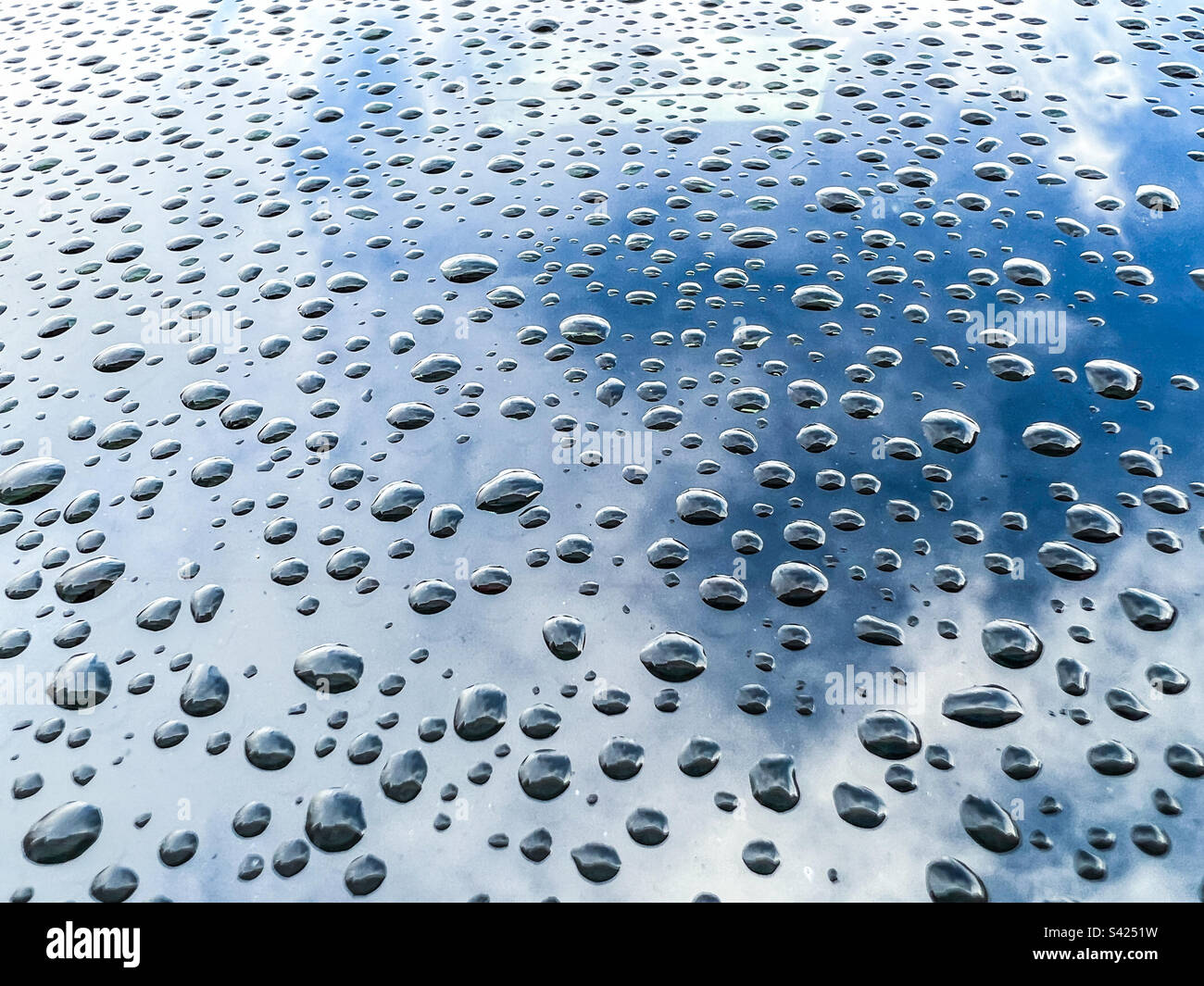 Grosses gouttes de pluie sur une surface métallique Banque D'Images