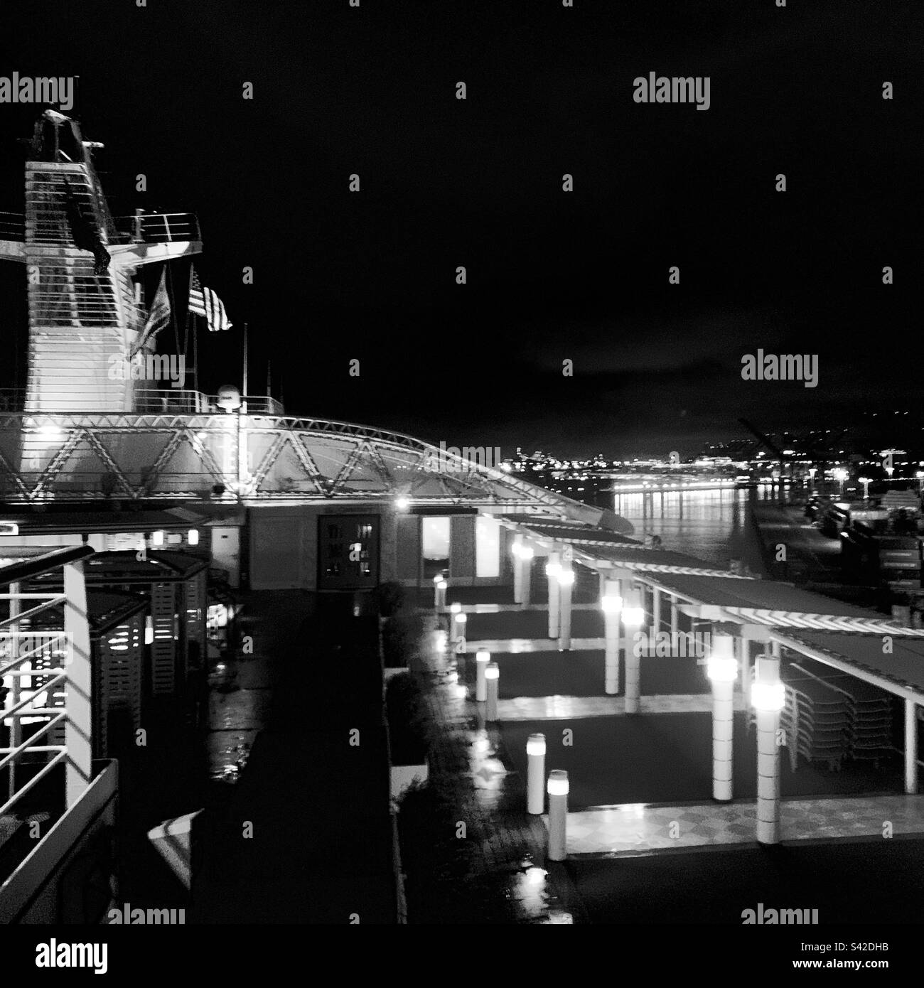 Image en noir et blanc d'un bateau de croisière dans un port la nuit Banque D'Images