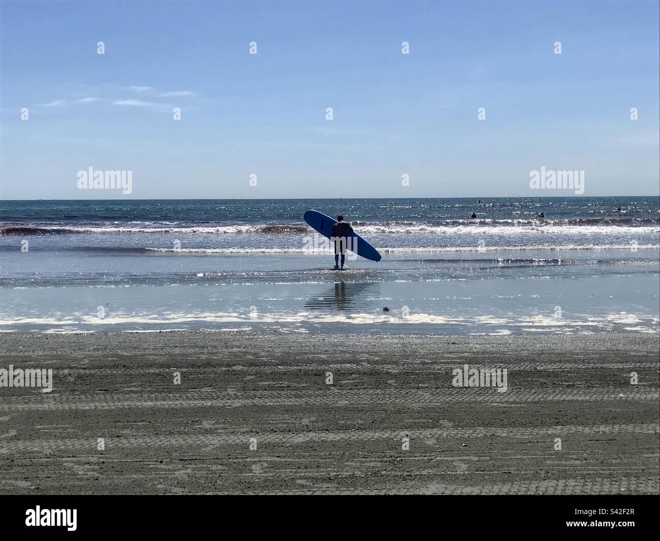 Jeune homme qui prend son surf dans l'eau à second Beach, Newport, Rhode Island - Image de stock capturée avec un smartphone