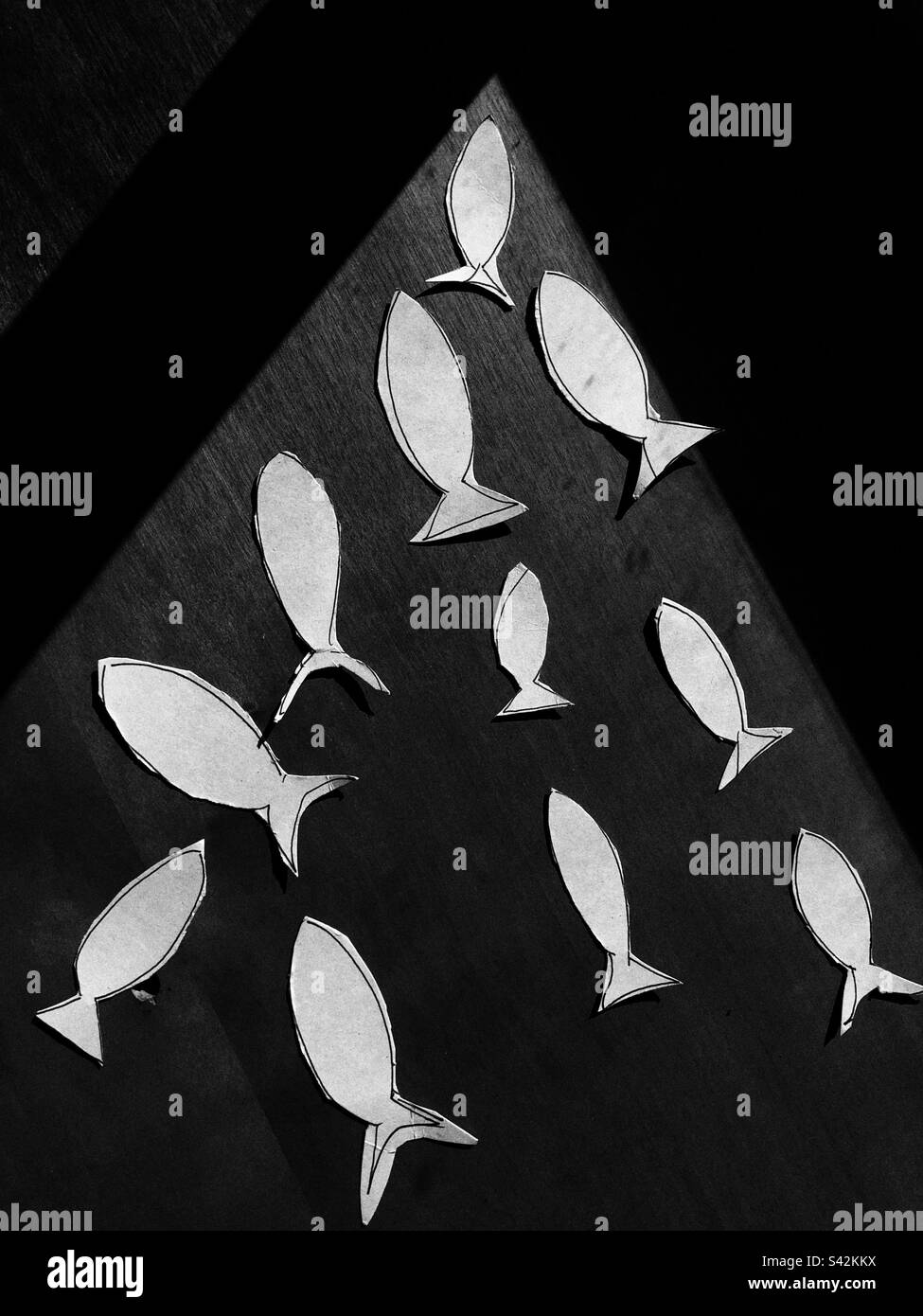 Composition de poisson coupé en papier sur une surface plane Banque D'Images
