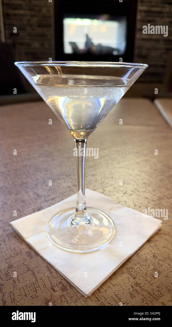 Martini de gin dans un verre de martini sur une serviette en face d'une cheminée à proximité - Image de stock capturée avec un smartphone
