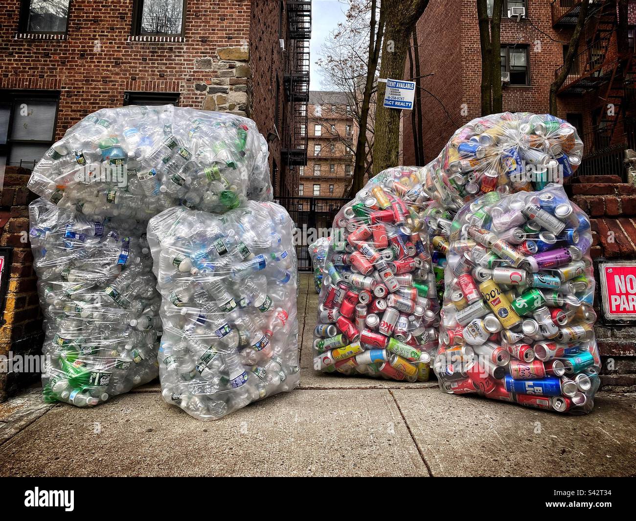 Bouteilles et canettes de soda, de bière et d'eau dans des sacs de recyclage. Banque D'Images
