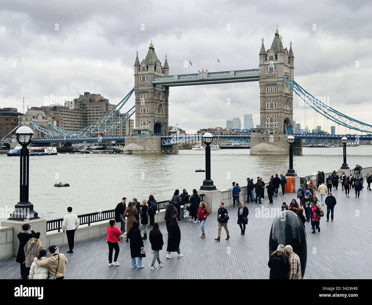 Piétons et touristes sur la Queens Walk donnant sur Tower Bridge Banque D'Images