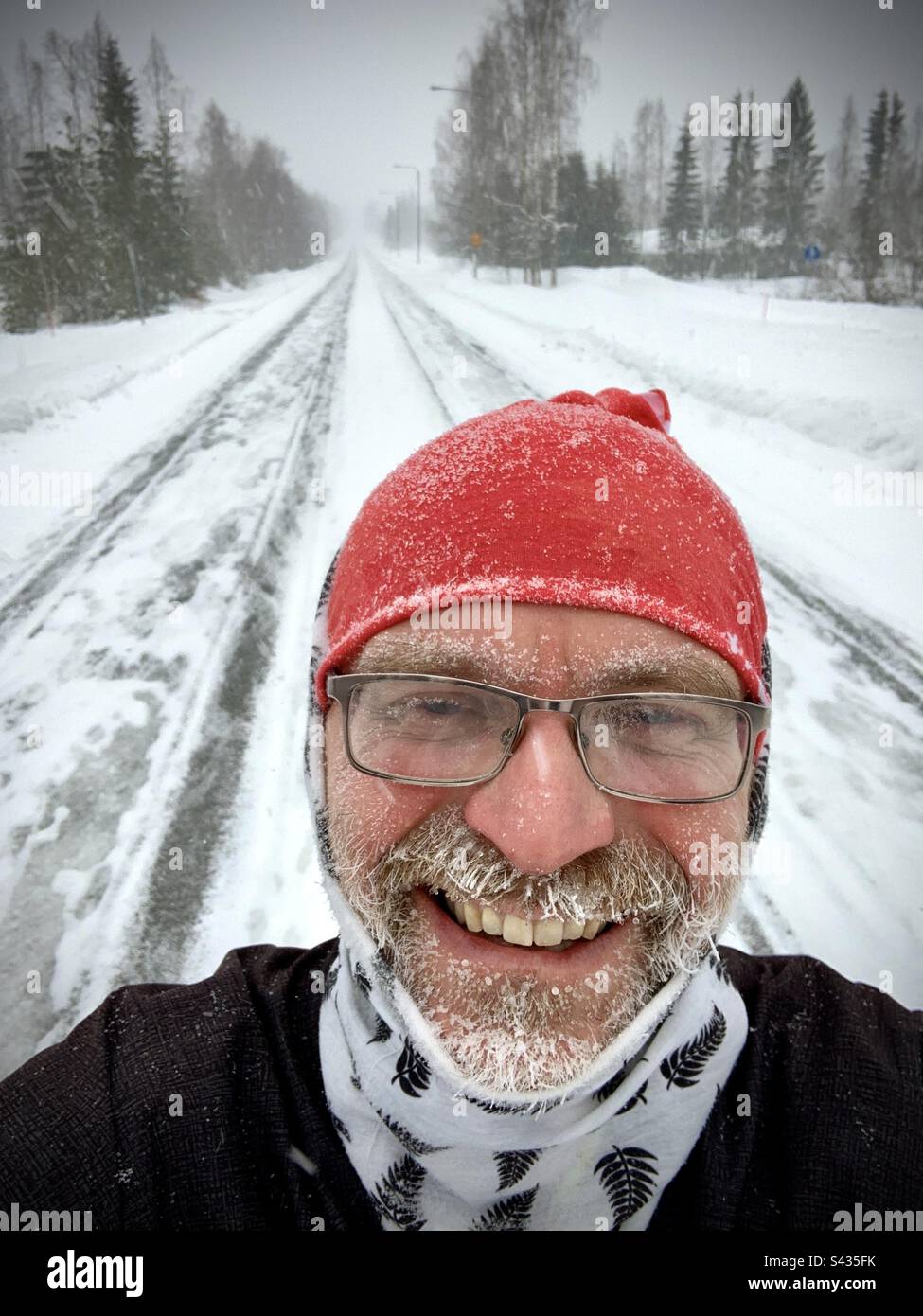 Un selfie drôle d'un homme d'âge moyen avec une barbe glacée après avoir coulé dans le froid extrême des profondeurs d'un hiver gelé dans la région du cercle arctique de Finlande Banque D'Images
