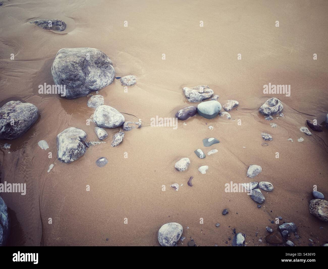 Une photo en gros plan d'une plage de sable avec des rochers et des rochers - Image de stock capturée avec un smartphone