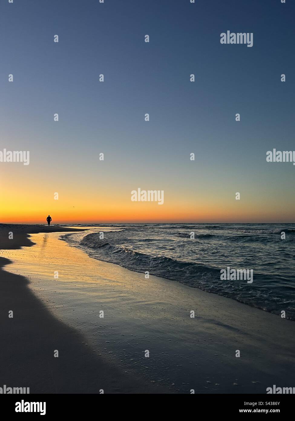 Lever de soleil sur la plage avec silhouette de personne Banque D'Images