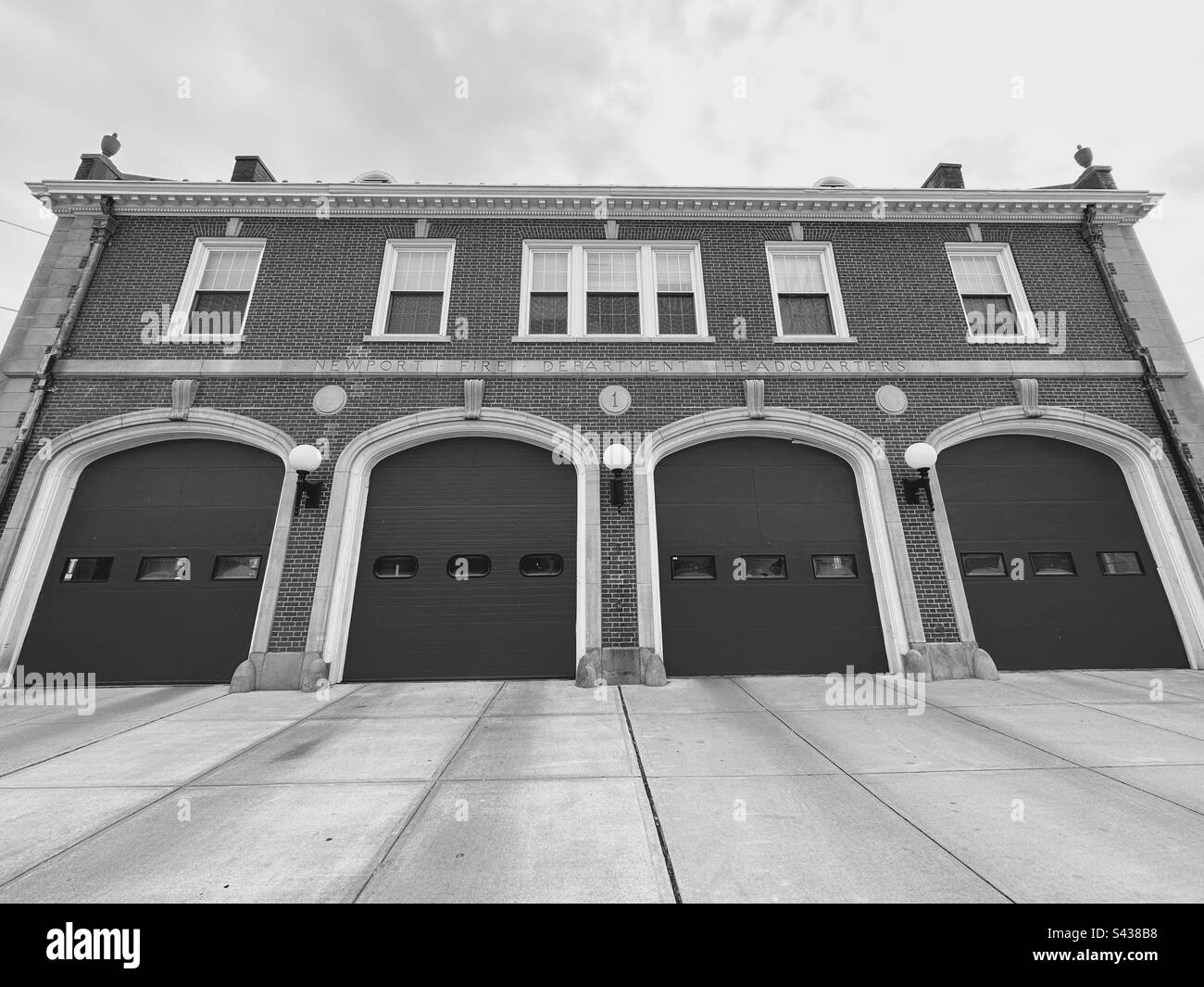 Newport, Rhode Island, États-Unis - Siège du service des incendies de Newport avec un bâtiment en briques et quatre (4) grandes portes. Allée en béton. Objectif grand angle. Filtre noir et blanc. Banque D'Images