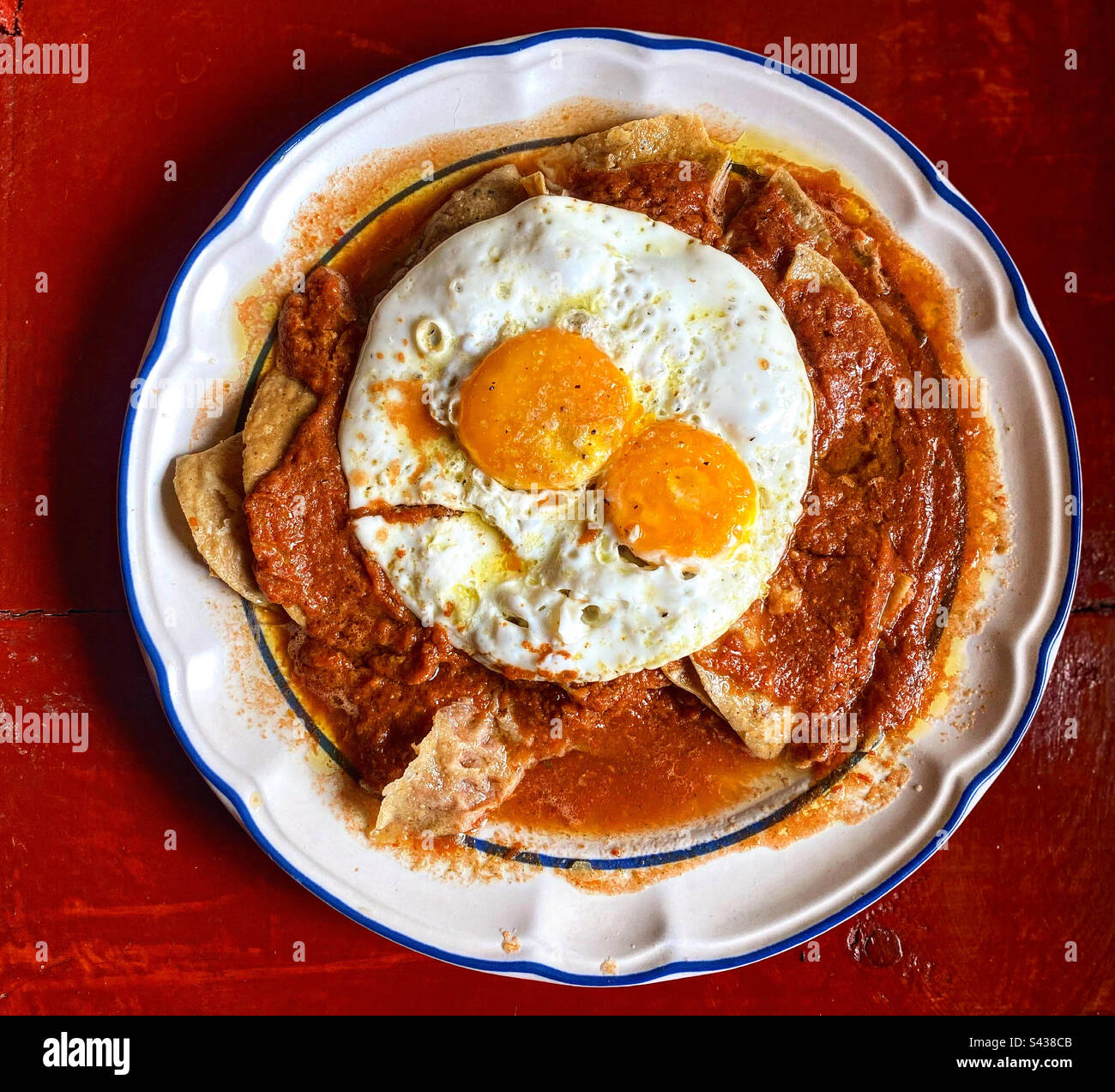 Chilaquiles à la sauce tomate rouge avec deux œufs frits au Mexique Banque D'Images