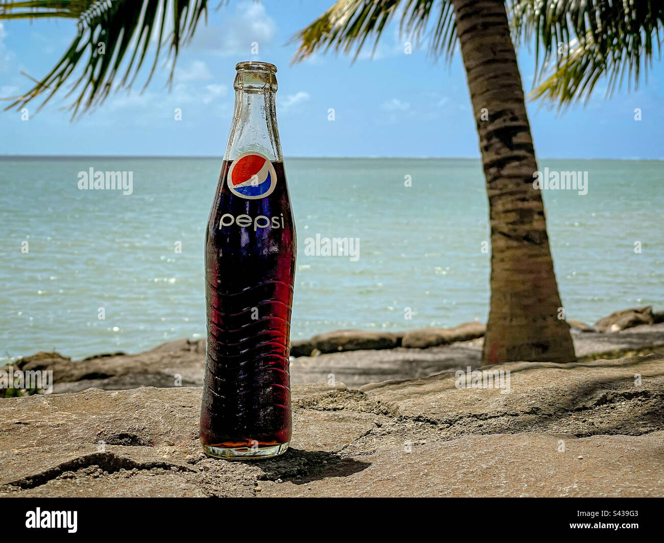 Bouteille de boisson en verre Pepsi cola sur la plage tropicale de l'île Maurice. Les bouteilles en verre ont été retournées à l'atelier afin de réduire la pollution et les déchets Banque D'Images