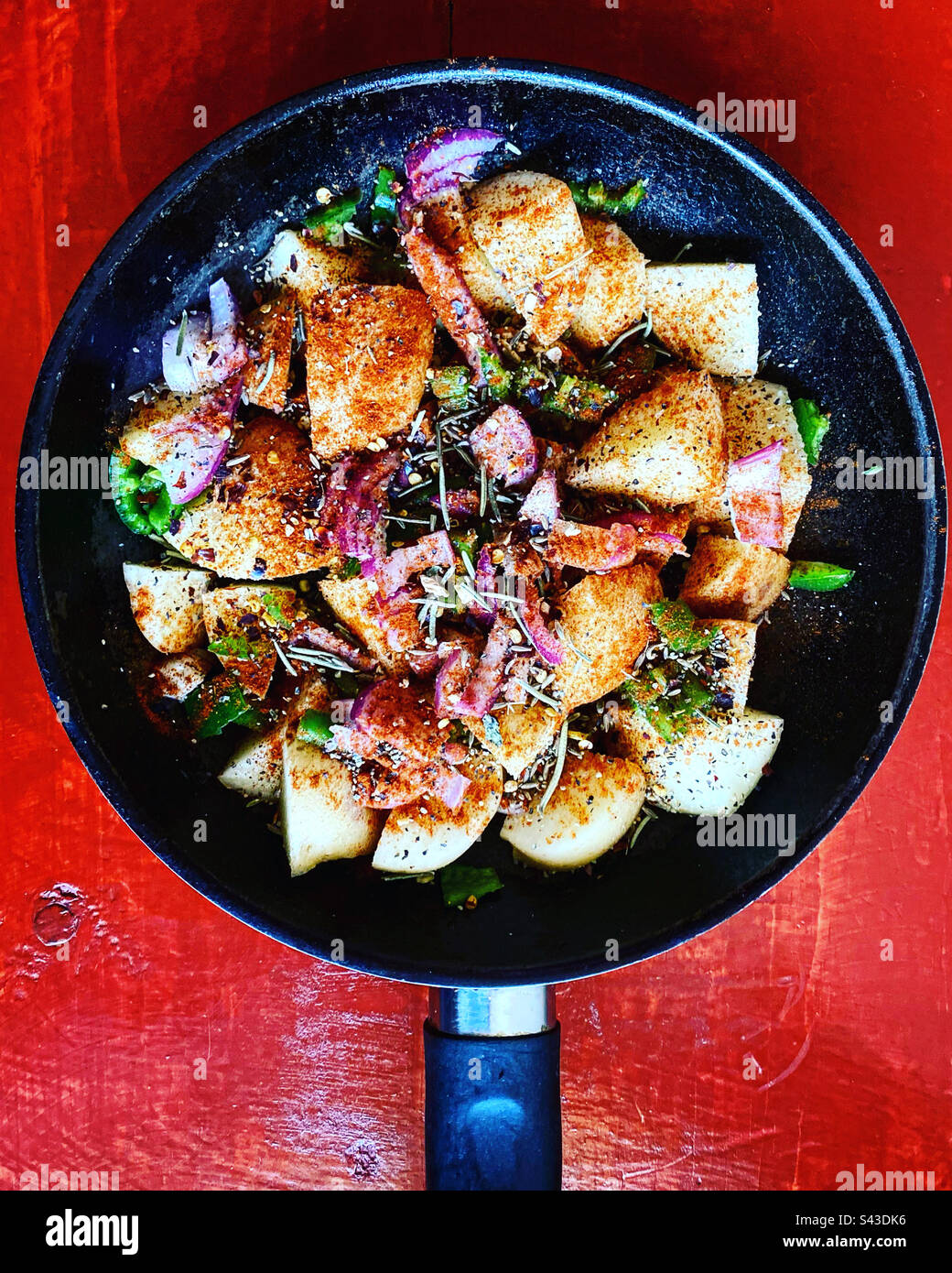 Papas bravas, oignon, pommes de terre épicées avec piment vert sur une casserole sur une table rouge à Queretaro, Mexique Banque D'Images