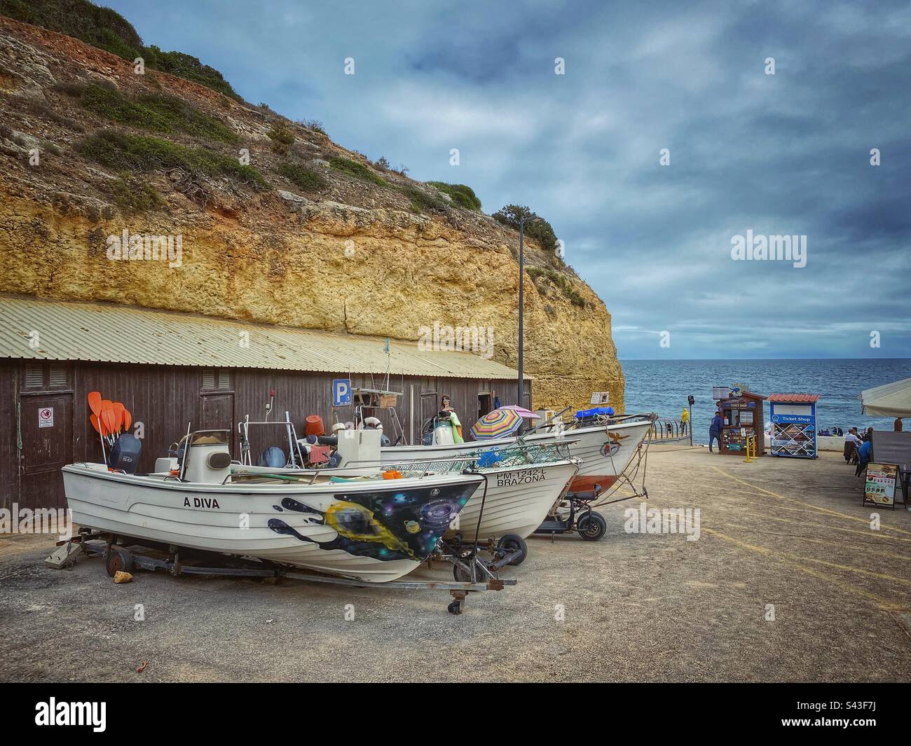 Bateaux garés et falaises de grès sur la plage de Benagil en Algarve, Portugal. Banque D'Images