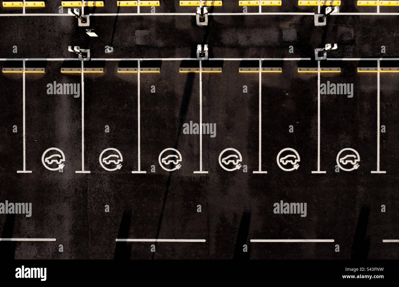 Vue aérienne au-dessus des rangées de places de stationnement avec panneaux de charge de véhicule électrique - Image de stock capturée avec un smartphone Vue aérienne au-dessus des rangées de places de stationnement avec panneaux de charge de véhicule électrique - Image de stock capturée avec un smartphone