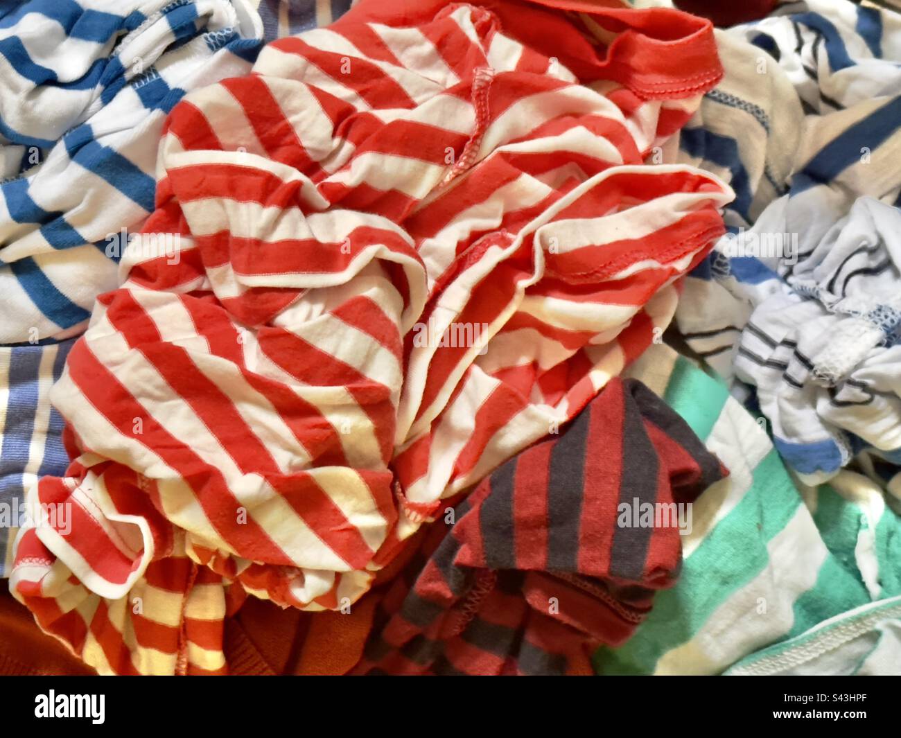 Un panier de mouillés, à laver, dans des tissus colorés à rayures Banque D'Images