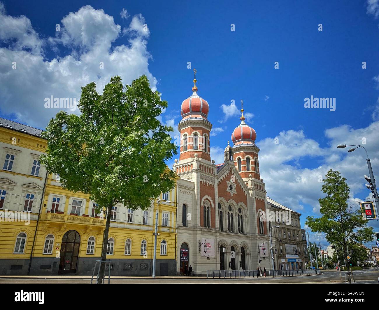 La grande synagogue de Pilsen construite au 19th siècle avec des arbres et des bâtiments jaunes, République tchèque. Banque D'Images