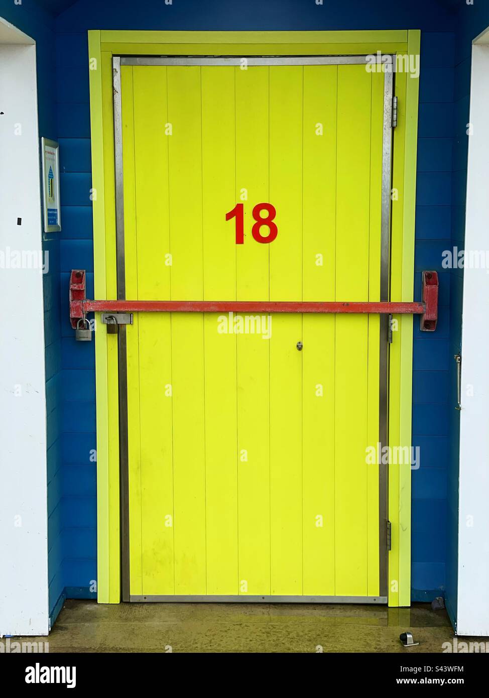 18 sur une porte jaune d'une cabane de plage. Banque D'Images