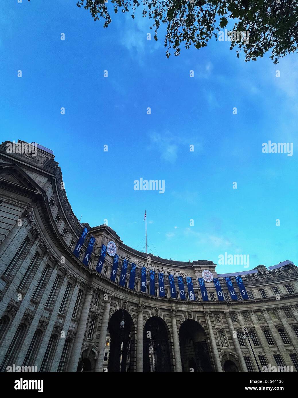 Les arbres reflètent les influences environnementales avec le couronnement du roi Charles III et une arche d'Amirauté décorée à Londres - Image de stock capturée avec un smartphone
