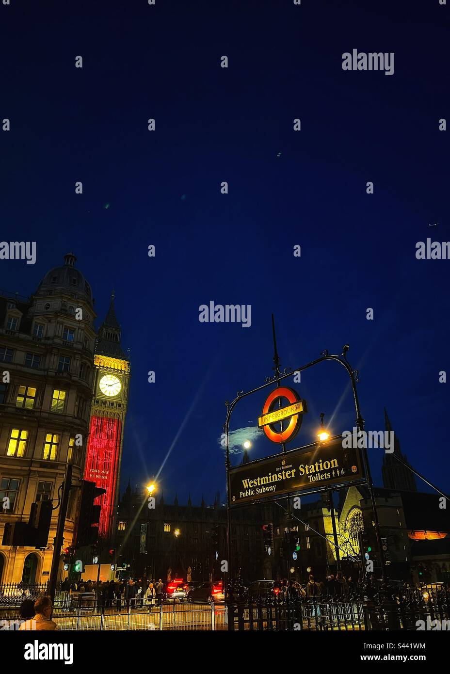 Whitehall et Parliament Square, perspective avec l'entrée de la station de métro de Westminster, la lune montante, l'horloge connue sous le nom de Big Ben et le Palais de Westminster allumé pour le couronnement - Image de stock capturée avec un smartphone